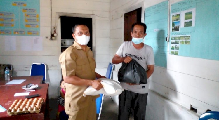 Sekretaris Dinas PMDS Lebong, Hedi Parindo saat menyerahkan paket bansos jadup kepada perwakilan pasien Covid-19 di salah satu Kantor Pemdes, Kamis (8/7)/RMOLBengkulu
