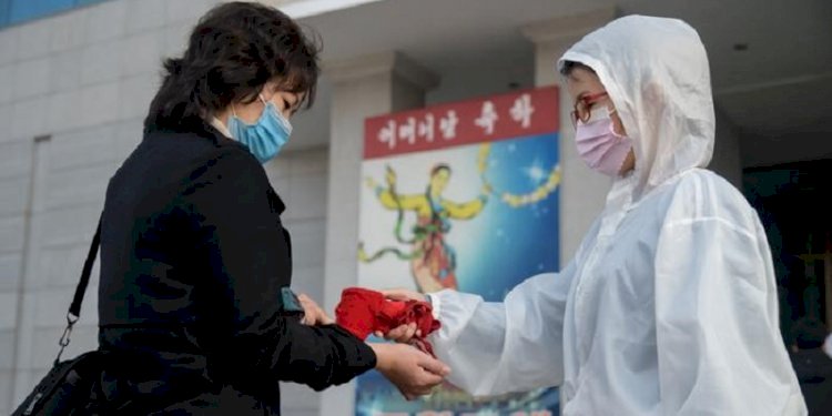 Petugas kesehatan Korea Utara memeriksa suhu/Net