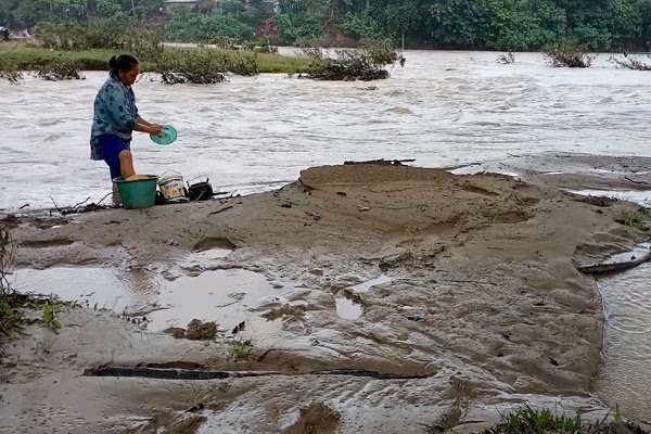 Salah seorang warga Desa Pulau Panggung Kecamatan Tanjung Agung, Muara Enim yang sedang mencuci piring di Sungai Enim. (noviansyah/rmolsumsel.id)