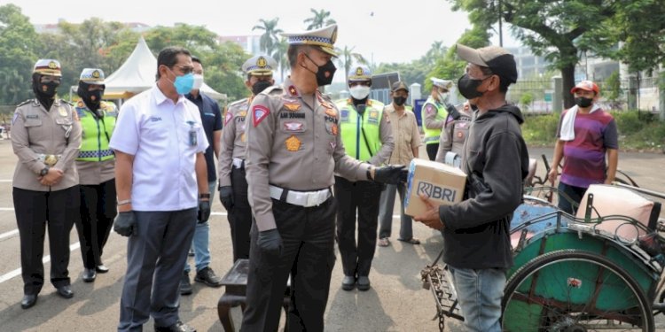 Dirgakkum Korlantas Polri Brigjen Pol Aan Suhanan membagikan sembako untuk tukang becak di kawasan Kemayoran, Jakarta Utara/Ist
