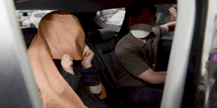 Wanita yang dituduh membunuh buah hatinya, duduk di atas mobil saat dia meninggalkan kantor polisi Ulsan Jungbu di Korea Selatan/ Foto: AP