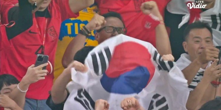 Suporter Korea Selatan bersorak usai Hwang Hee-chan menyarangkan bola ke gawang Portugal/Net