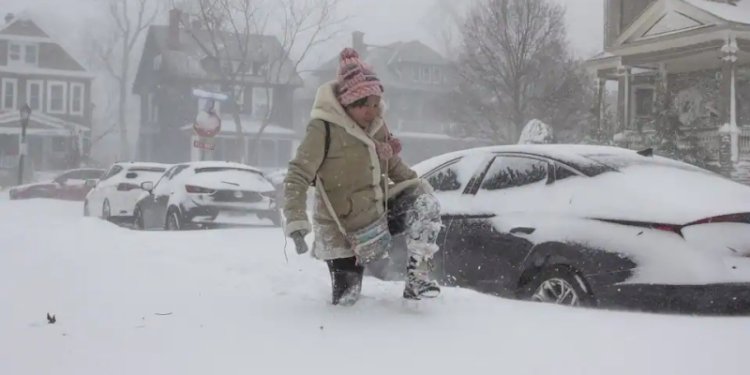 Seorang perempuan dari Buffalo, New York, melewati salju tebal saat badai musim dingin yang dahsyat menghantam beberapa wilayah di Amerika Serikat/Net