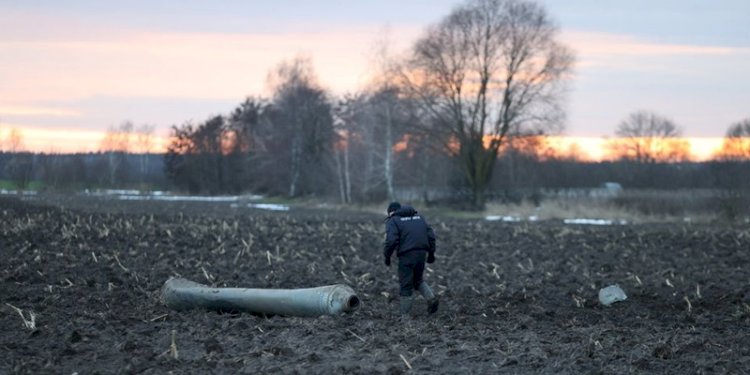 Penyelidik berjalan di dekat pecahan amunisi yang diperkirakan bagian dari rudal S-300 Ukraina yang dijatuhkan oleh pertahanan udara Belarusia di dekat desa Harbacha di wilayah Grodno/Net