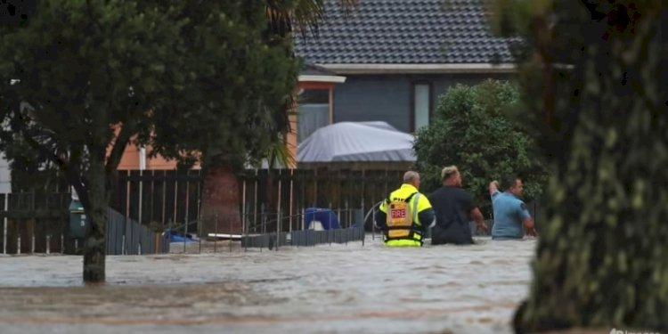 Petugas darurat dan warga mengarungi banjir di Auckland pada Jumat, 27 Januari 2023/CNA